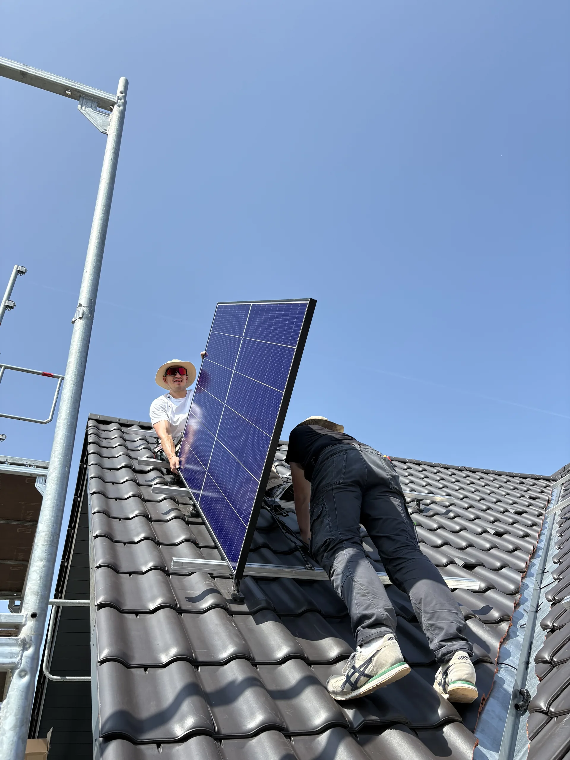 Photovoltaik-Modulmontage durch Monteure auf Ziegeldach